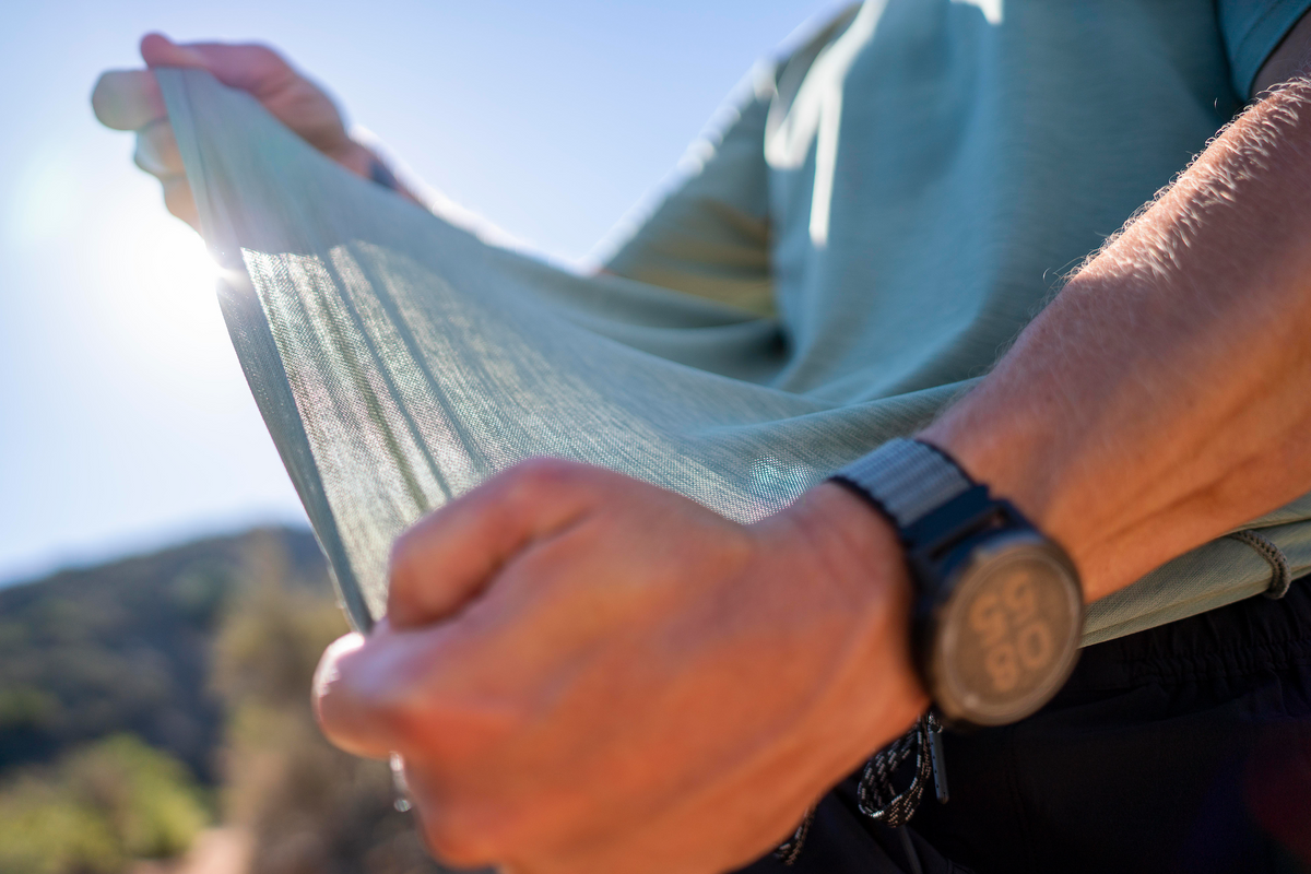 Close-up of Anetik lightweight breathable performance fabric being stretched to show flexibility and comfort outdoors